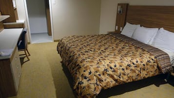 A hotel room with a bed, a desk, and a chair.