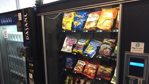 A vending machine stocked with snacks and a water dispenser. - Castle Inn (San Francisco)