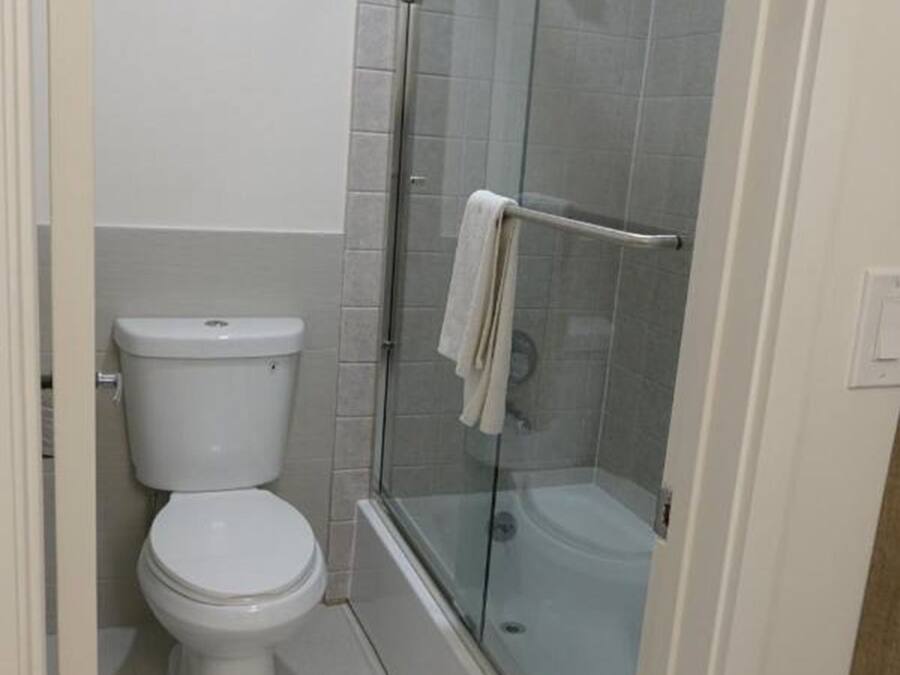 A bathroom with a toilet, a glass-enclosed shower, and a bathtub.