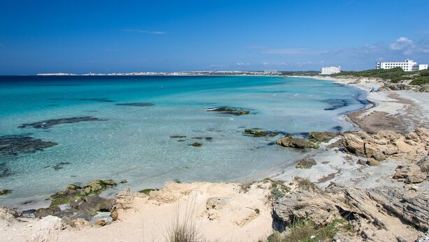 A coastal view with clear turquoise waters, rocky shoreline, and buildings in the distance. - Joli Park Hotel (Gallipoli)