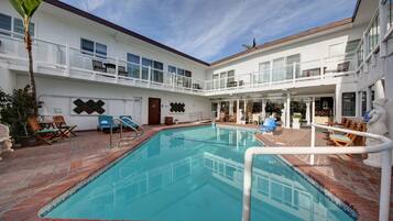 Una piscina al aire libre, una piscina climatizada, sombrillas