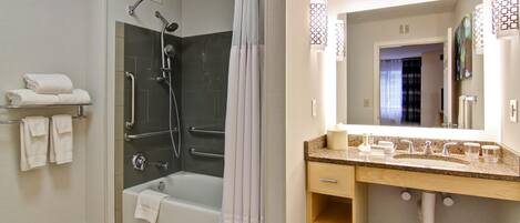 Un baño moderno con ducha, bañera y tocador con espejo.