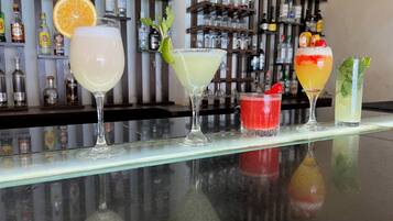 Eine Bar mit verschiedenen Cocktails, verziert mit unterschiedlichen Früchten und Kräutern.