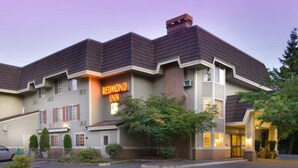 A Redmond Inn hotel with a modern design, featuring a prominent neon sign, a well-maintained exterior, and a parking lot. - Redmond Inn (Redmond)