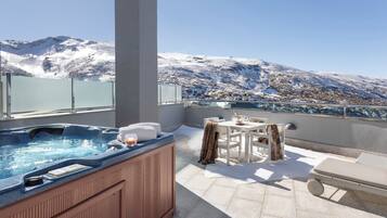 Un jacuzzi en un balcón con vista a la montaña.
