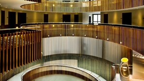 A multi-level atrium with a central circular staircase, wooden railings, and a skylight with purple lighting. - Melia Sol Y Nieve (Monachil)