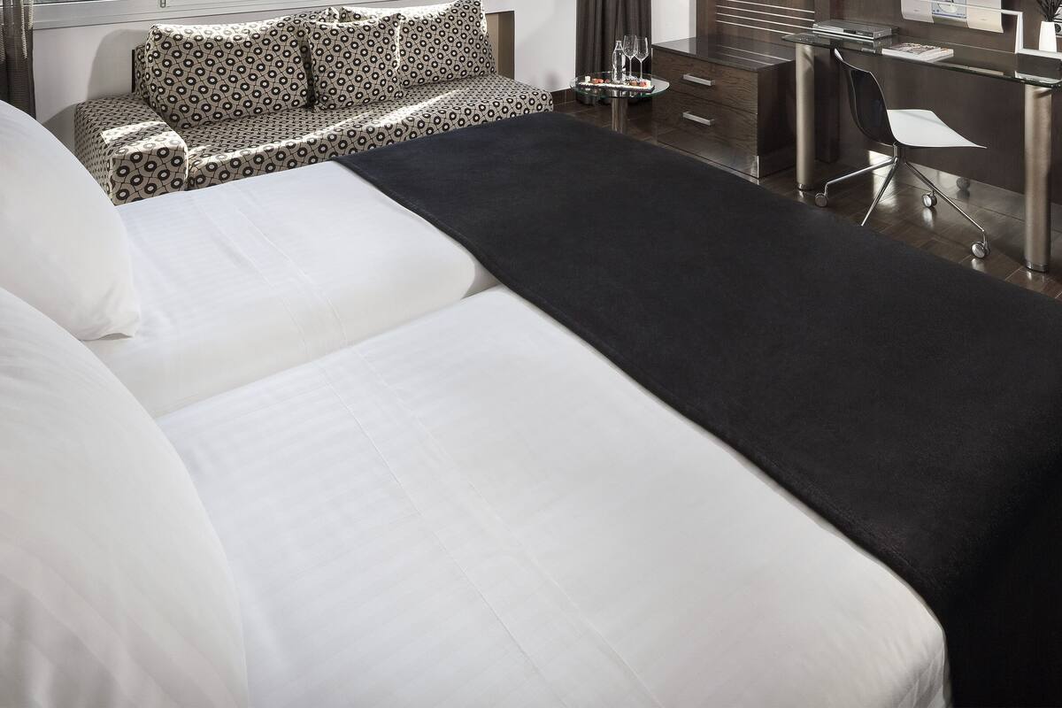 Una habitación de hotel con una cama grande, un escritorio y una silla.