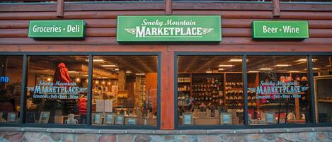 Un escaparate con letreros que indican 'Groceries', 'Deli', 'Beer', y 'Wine'.