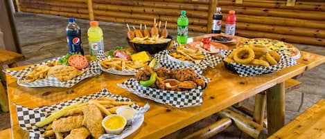 A table with various fried foods, condiments, and beverages.