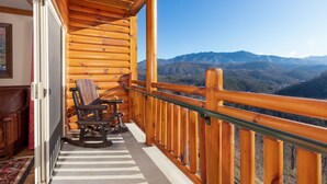 A wooden balcony with a view of mountains.