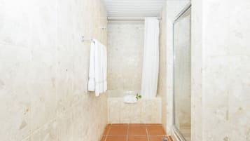 A bathroom with a shower, a bathtub, and a glass-enclosed shower stall.