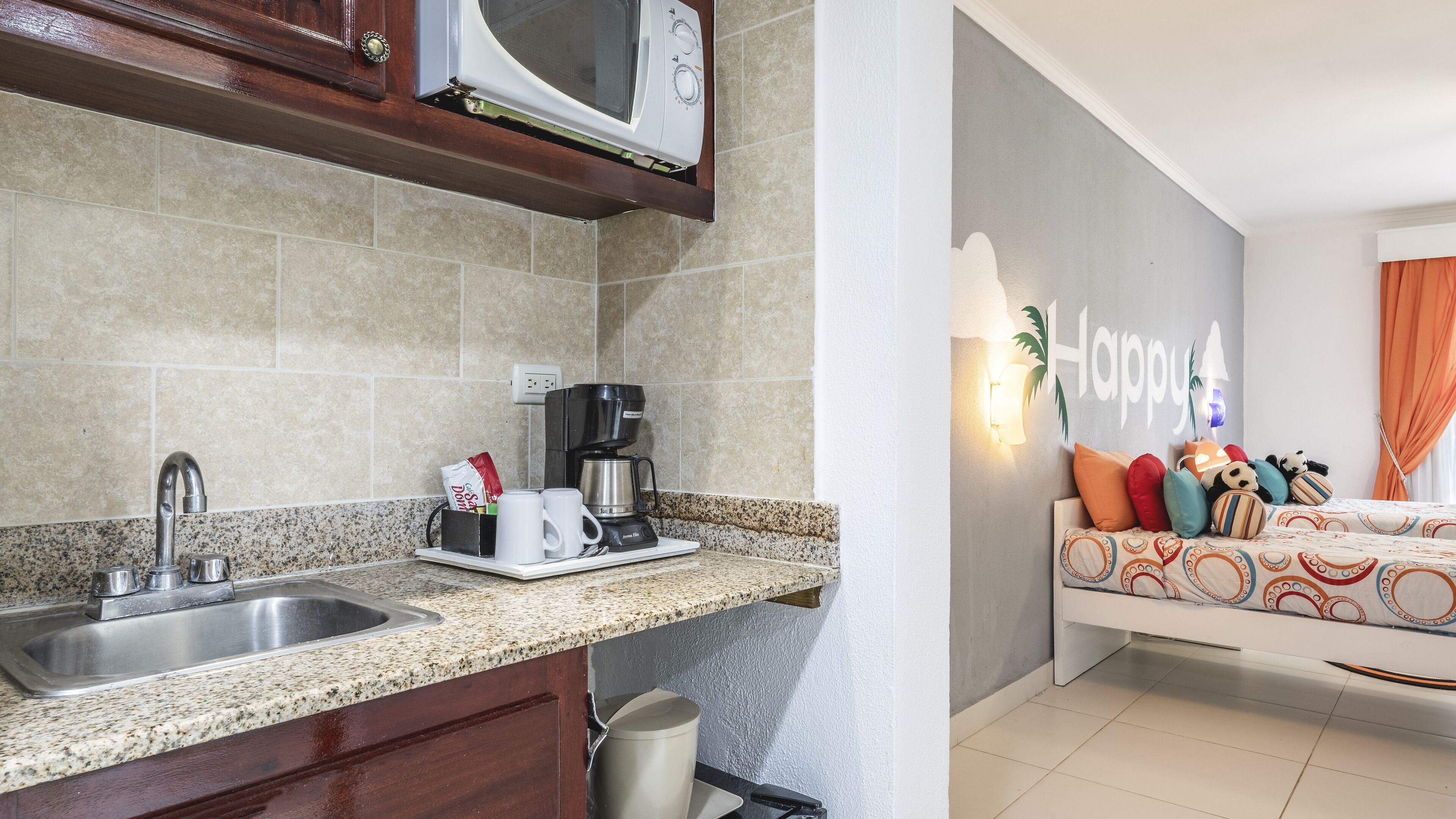 A modern kitchen with granite countertops, a built-in microwave, and a coffee maker.