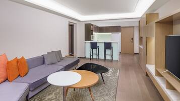 A modern living room with a sofa, a coffee table, and a TV stand.