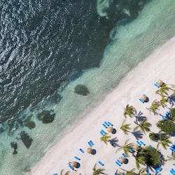 On the beach, white sand, sun loungers, beach umbrellas