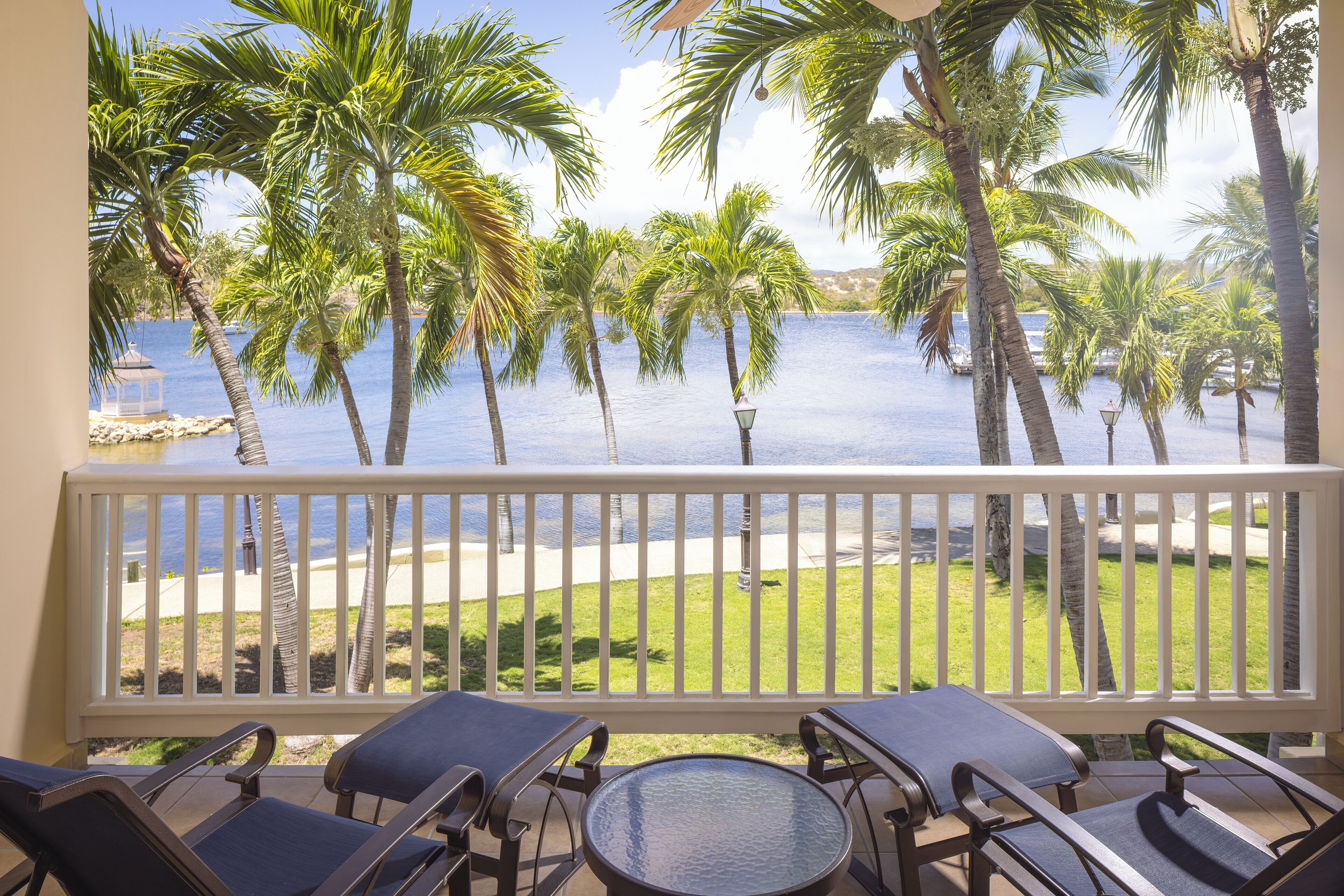 Ein Balkon mit Blick auf einen Strand und Palmen.