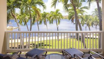 Ein Balkon mit Blick auf einen Strand und Palmen.