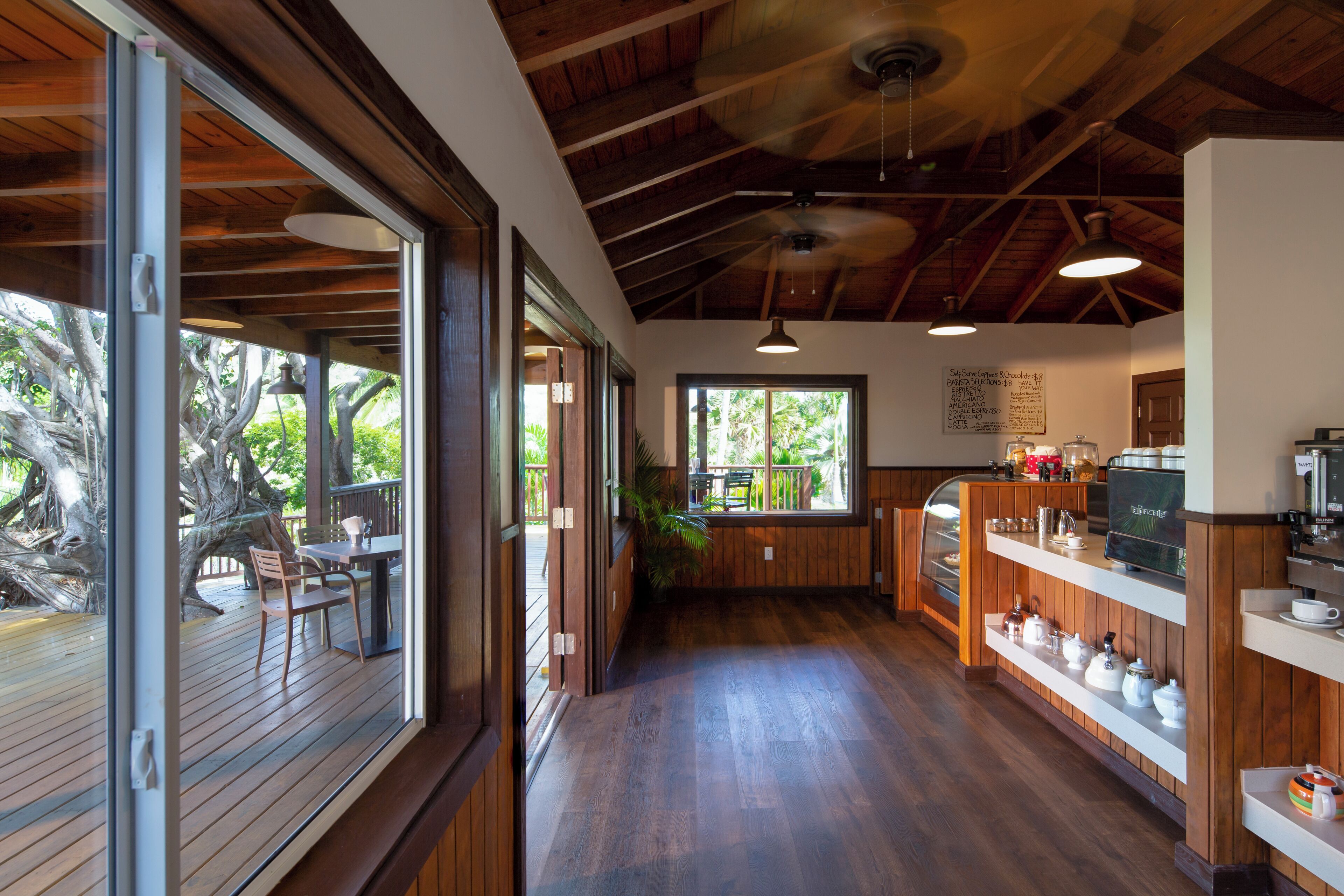 Un intérieur en bois comprenant un coin repas, une cuisine et de grandes fenêtres.