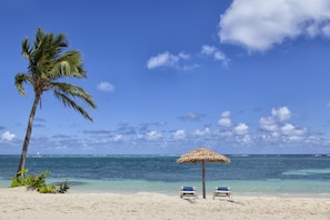 On the beach, white sand, sun-loungers, beach umbrellas