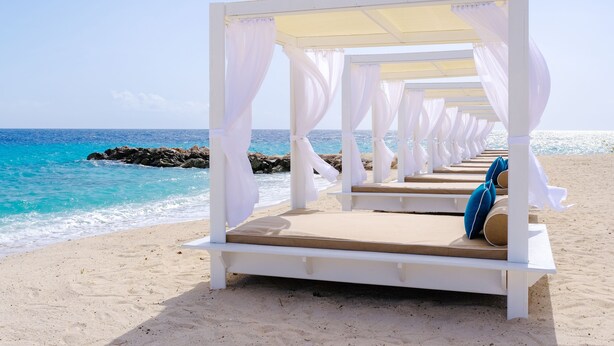 A row of white beach cabanas with cushions, overlooking the ocean. - Zoetry Curaçao Resort & Spa - All Inclusive (Willemstad)