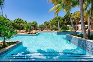 Una piscina al aire libre, camas de piscina gratis, sombrillas