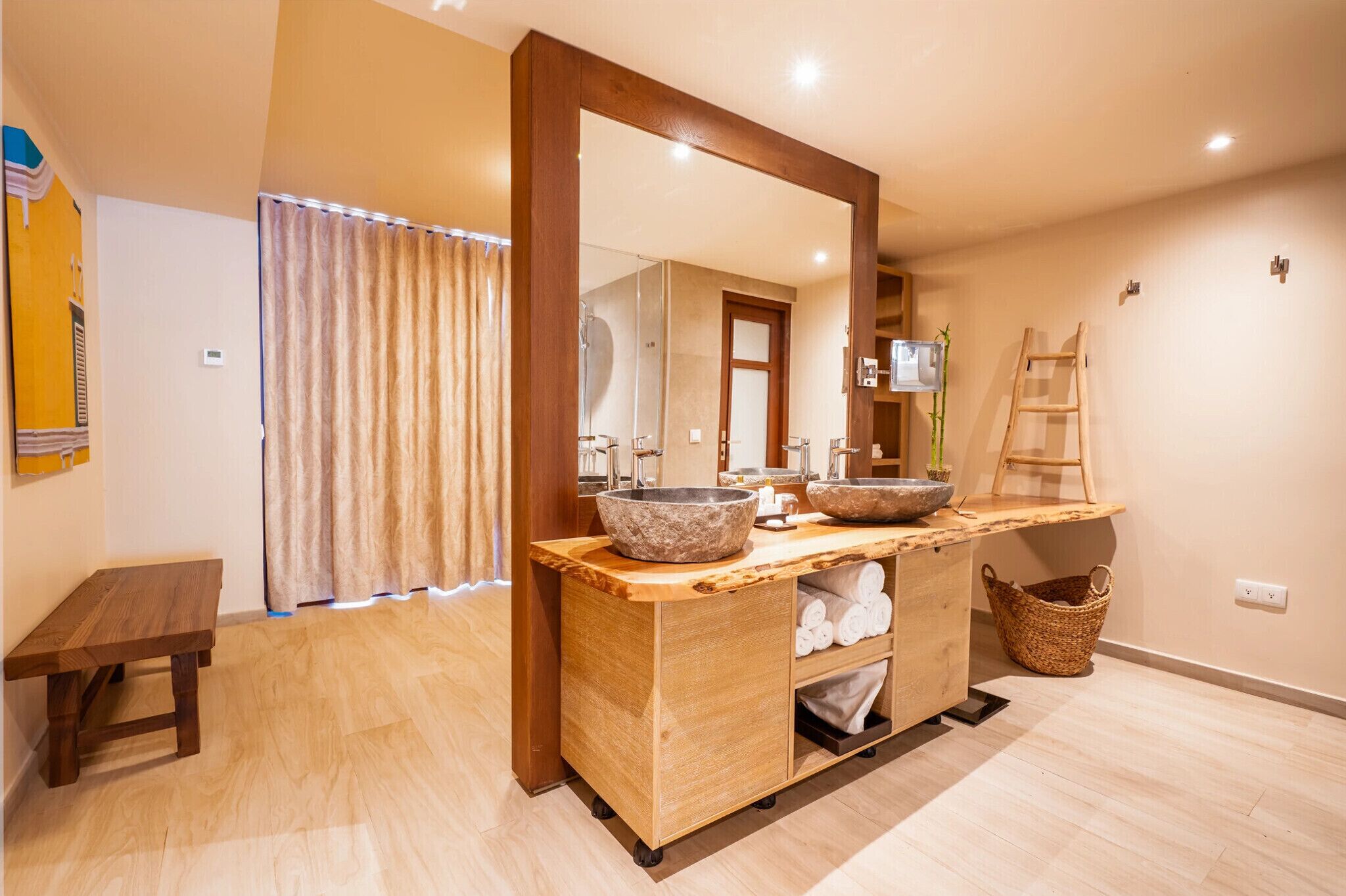 Ein modernes Badezimmer mit einem Holzkosmetikschrank, großen Spiegeln und einer Badewanne.