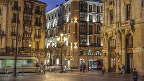 A historic building with ornate architecture, a prominent entrance, and a tram passing by. - Petit Palace Arana (Bilbao)