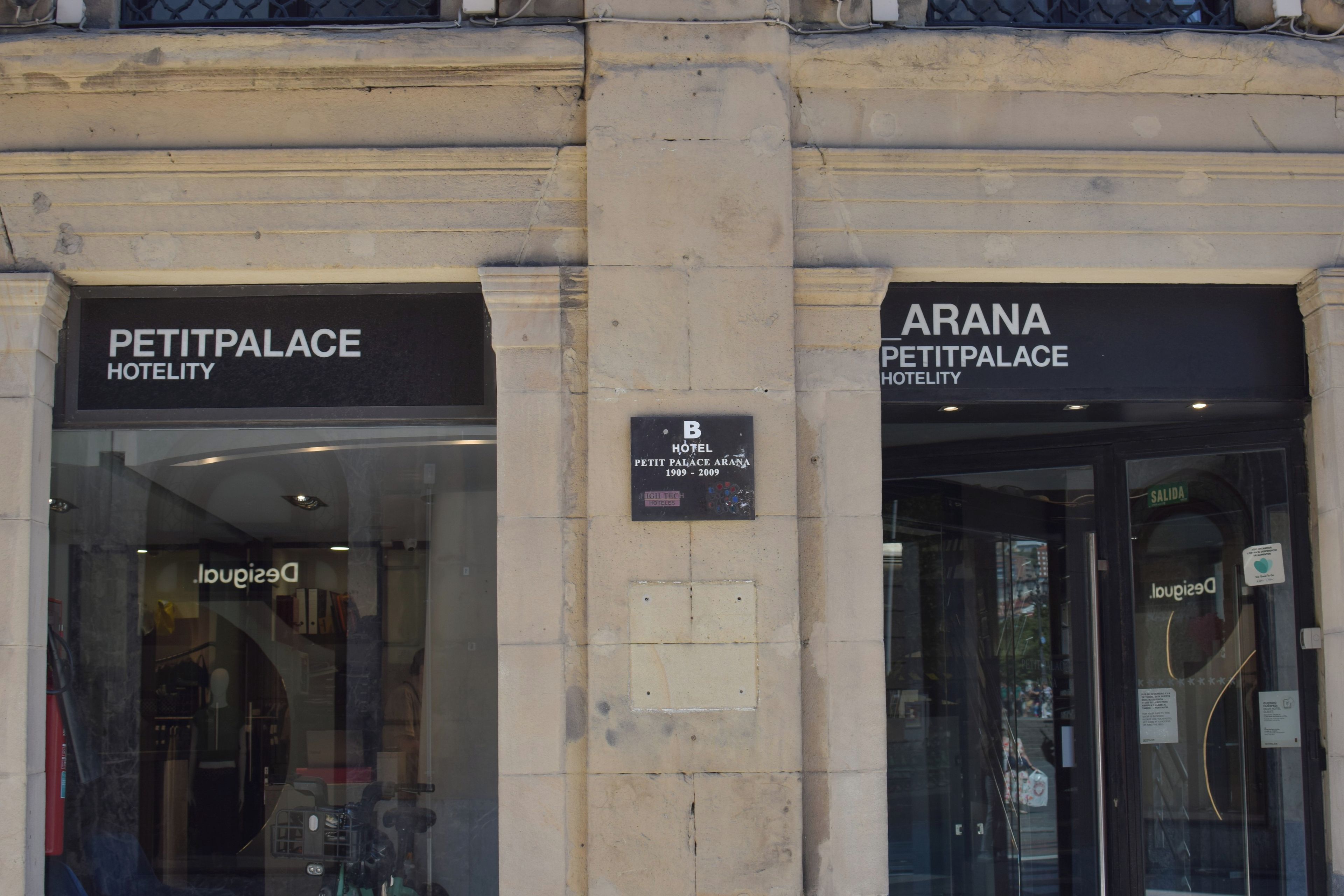 La entrada al Hotel Petit Palais, con señalización que indica el nombre y la ubicación.