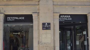 La entrada al Hotel Petit Palais, con señalización que indica el nombre y la ubicación.