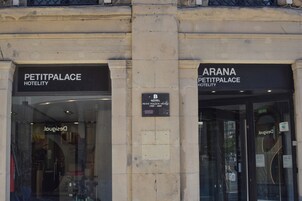 Entrada do Hotel Petit Palais, com placa indicando o nome e a localização.