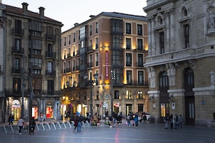 Um edifício histórico com vários andares, janelas amplas e uma entrada imponente.
