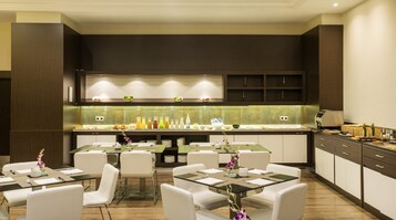 Ein moderner Hotel-Speisesaal mit einem Buffet, das eine Auswahl an Speisen und Getränken bietet.