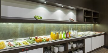 A buffet with various fruits, vegetables, and beverages.