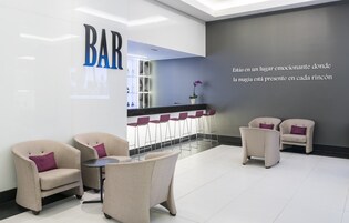 Un espace bar moderne avec des sièges et un comptoir d’accueil.
