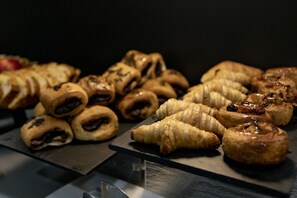 A variety of pastries displayed on a black slate board. - Petit Palace Cliper Gran Vía (Madrid)