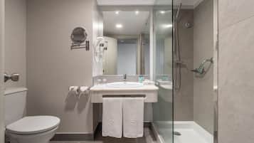 A modern bathroom with a toilet, sink, and glass-enclosed shower.