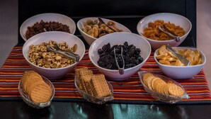 Un bufé con diversos alimentos, tazones de nueces y galletas.