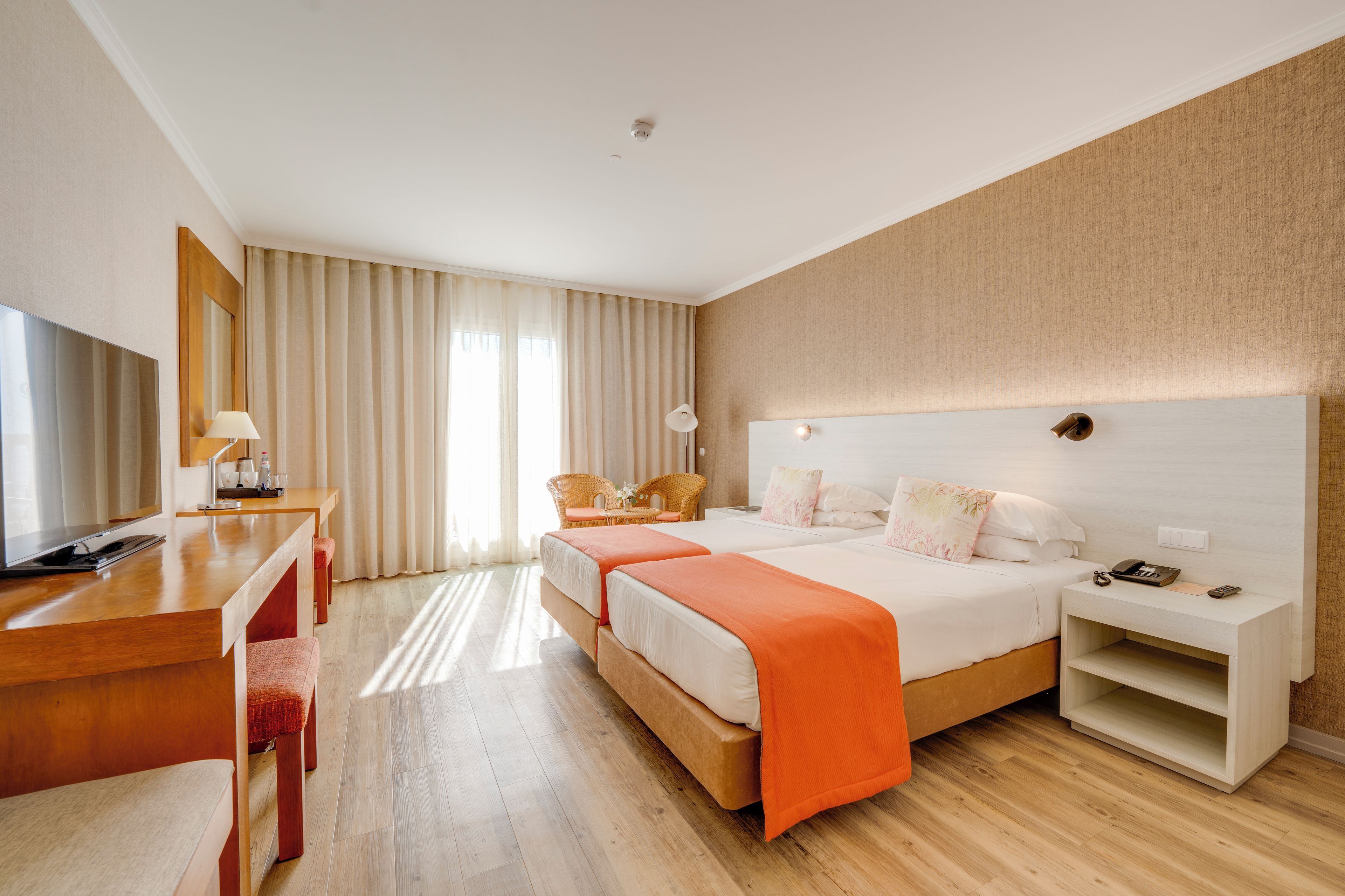 Een hotelkamer met een bed, een bureau, een stoel en een televisie.
