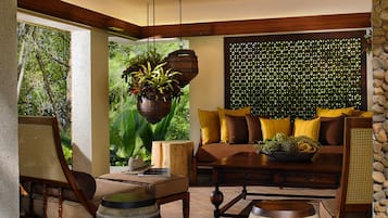 Un salón acogedor con un sofá de madera, una mesa de centro y una planta colgante.