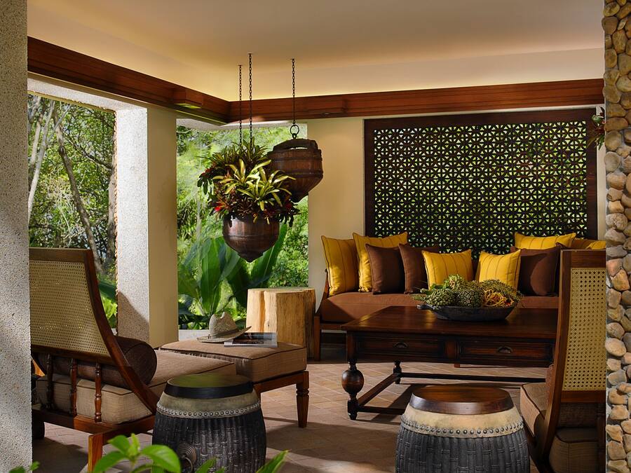 Un salón acogedor con un sofá de madera, una mesa de centro y una planta colgante.