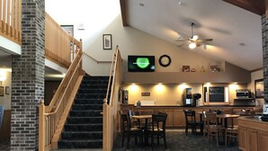 Une cuisine spacieuse avec un escalier en bois, un coin repas et un bar.