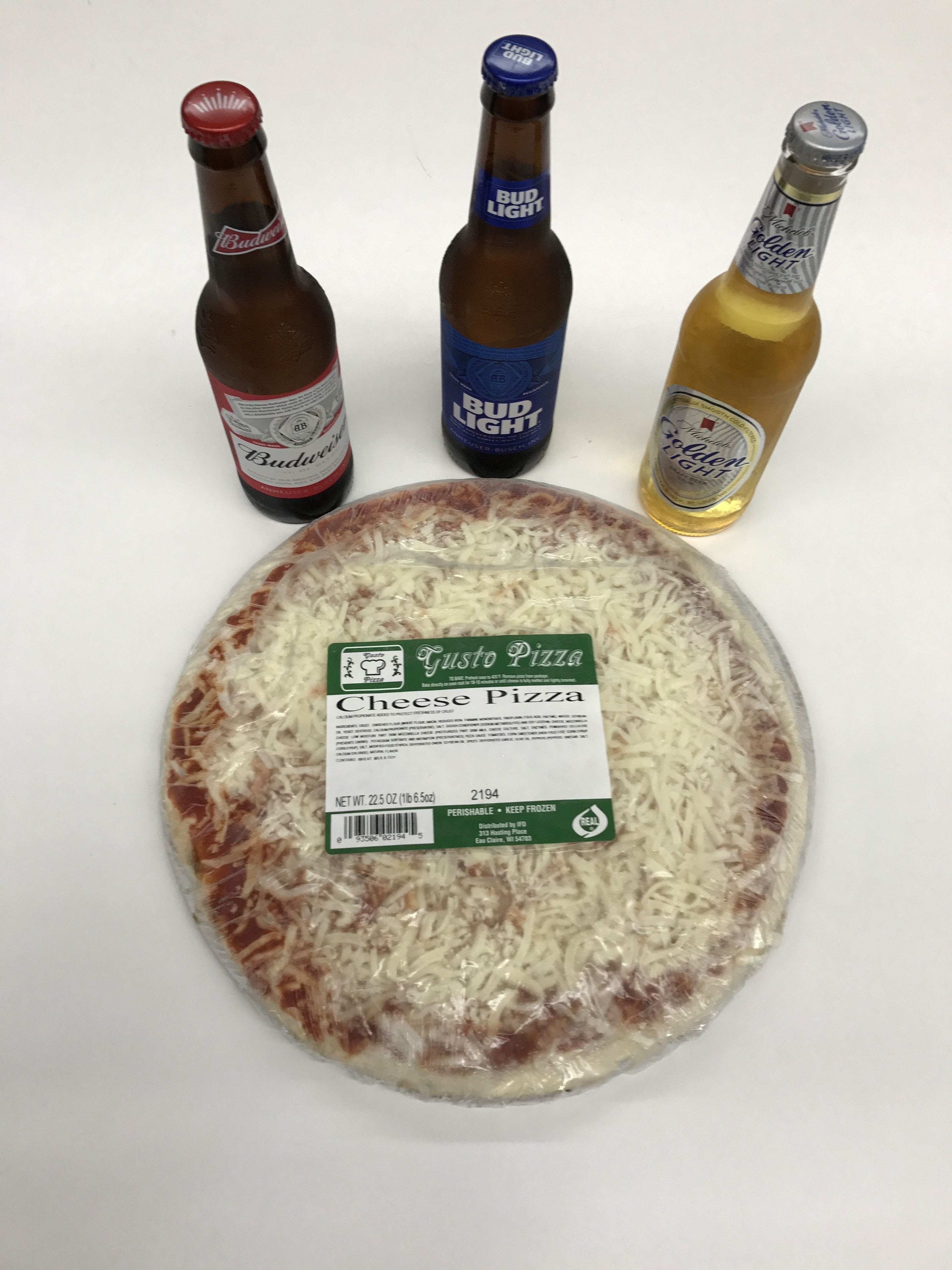 A cheese pizza with a label, and three bottles of beer.