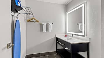 A modern bathroom with a large mirror, a sink, and a towel rack.