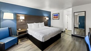 Une chambre d’hôtel moderne avec un grand lit, des tables de chevet, un bureau et une chaise.