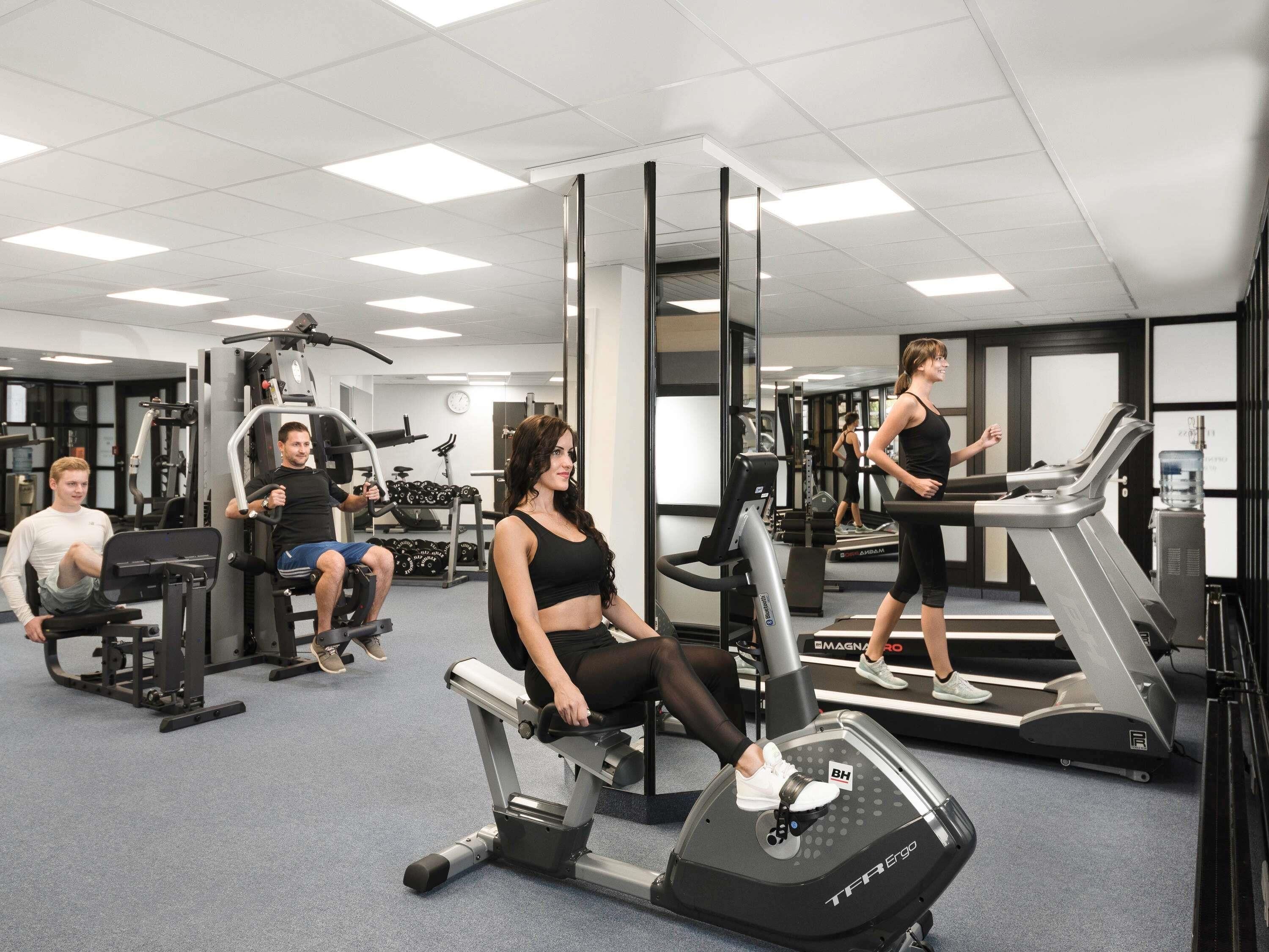A gym with various exercise equipment, including treadmills and weight machines.