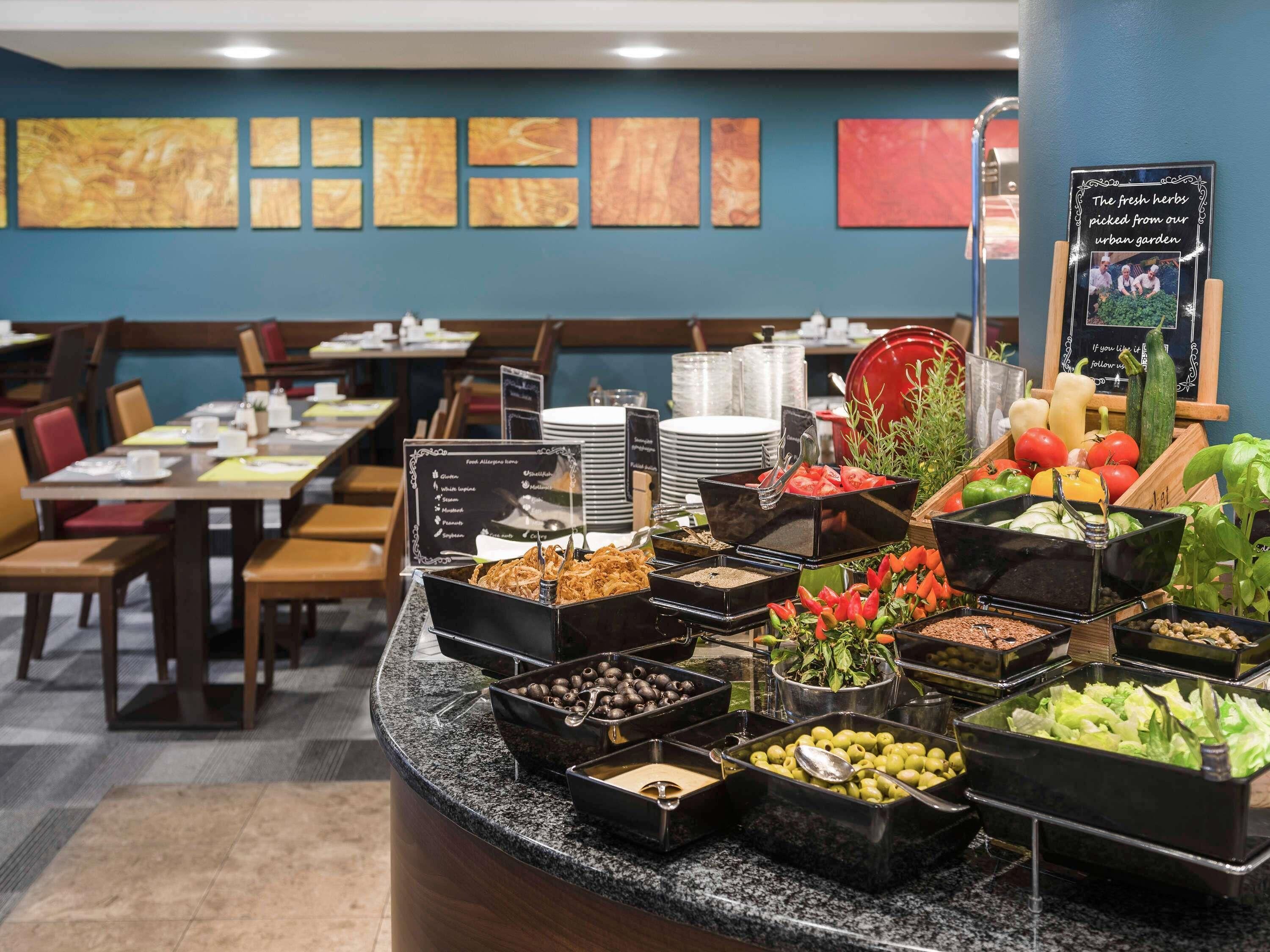 Zona de buffet amb diverses opcions de menjar i un menú escrit a la pissarra.