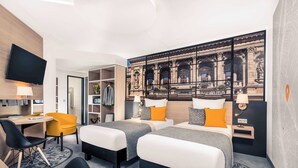 A hotel room with two beds, a desk, a chair, a TV, and a large mural of a historical building. - Mercure Budapest City Center Hotel (Budapest)