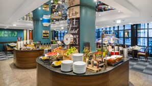 A buffet area with a variety of food items, a clock, and a sign that reads "Market". - Mercure Budapest City Center Hotel (Budapest)