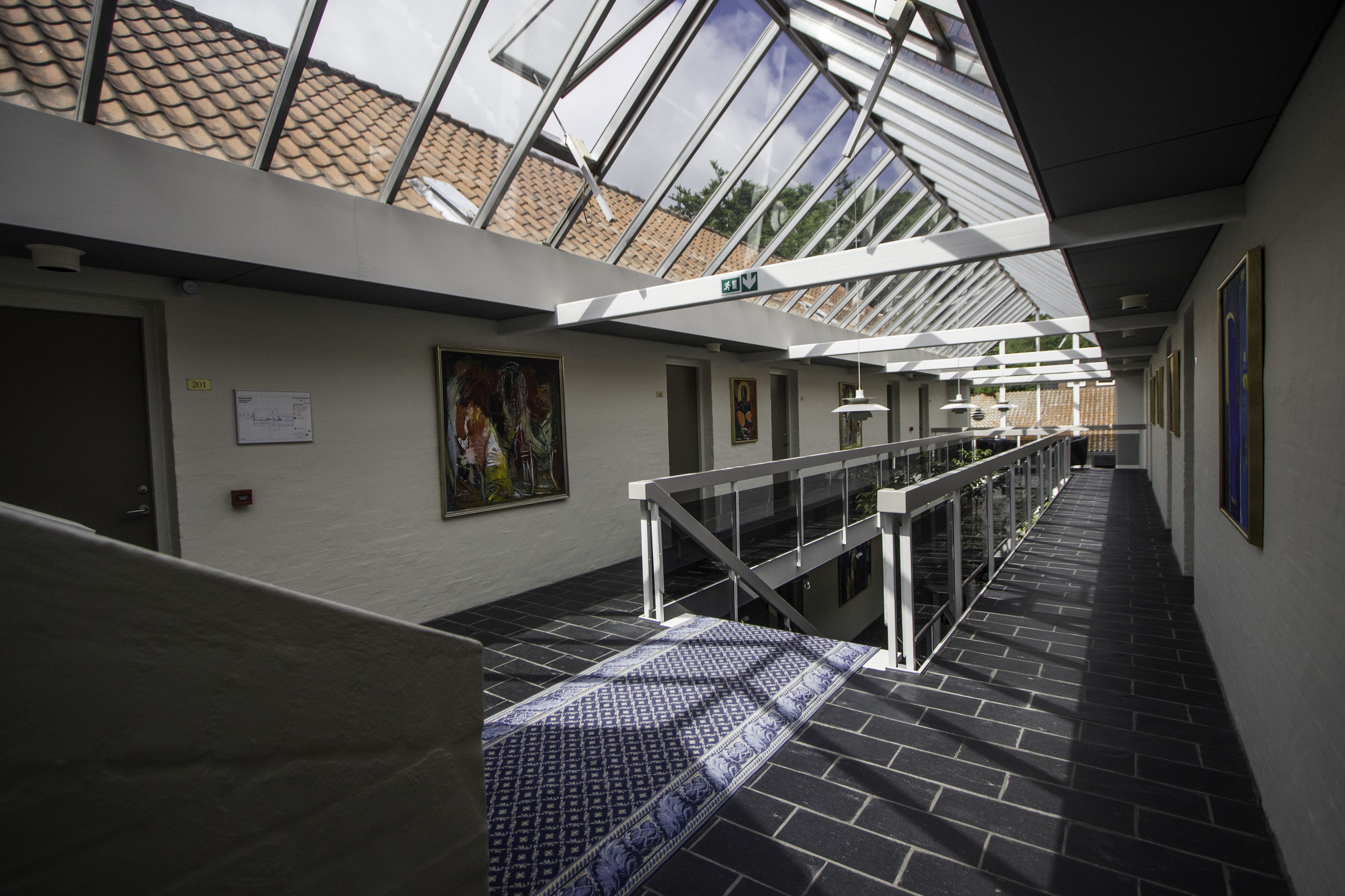 A modern interior with a glass ceiling, a staircase, and a patterned carpet.