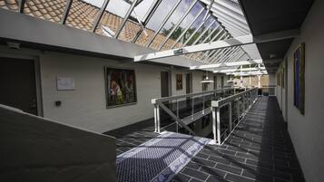 A modern interior with a glass ceiling, a staircase, and a patterned carpet.