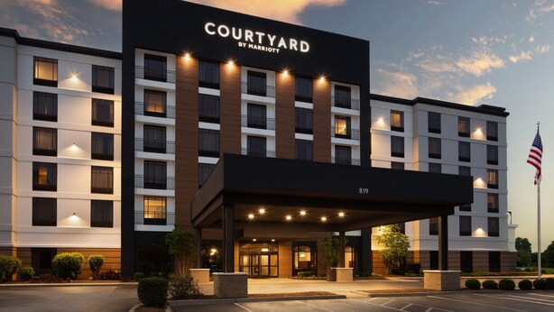 A Courtyard by Marriott hotel with a modern facade, multiple floors, and a well-lit entrance. - Courtyard by Marriott Louisville Airport (Louisville)